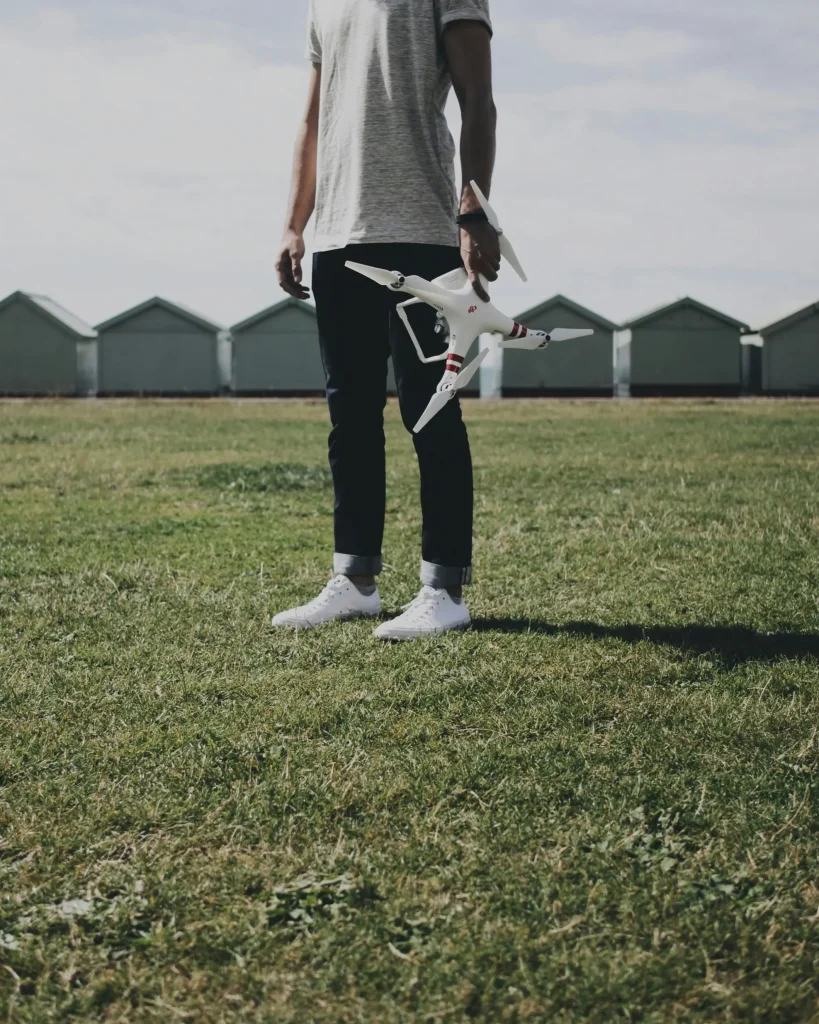 Man standing in field holding drone